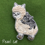 アルパカで暖を取る猫の刺繍ブローチ