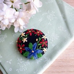 青い花を囲こむ赤花刺繍ブローチ