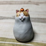 頭におみかん🍊を乗せた茶白ねっこの置物