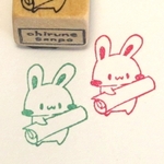 丸めた紙を持つうさぎ・ゴム版はんこ