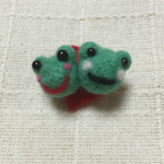 頬を寄せ合うカエルのブローチ