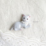 グレーの猫　白い花かざり　陶土ブローチ