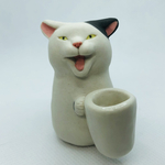 ヒゲ入れを持つブチねっこの置物