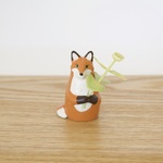 花を持つキツネの置物
