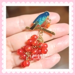 X ブローチ：鳥と赤いジャラジャラ果実