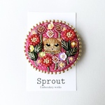 マゼンタの花園にいる茶トラ猫の刺繍ブローチ