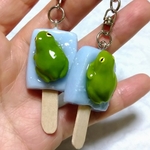 アイスキャンディーに身体が濡れたままのってしまいくっついて動けなくなっているカエルのキーホルダー