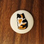 「ちょこんと座る三毛猫のみーちゃん」の刺繍くるみボタンマグネット(a)