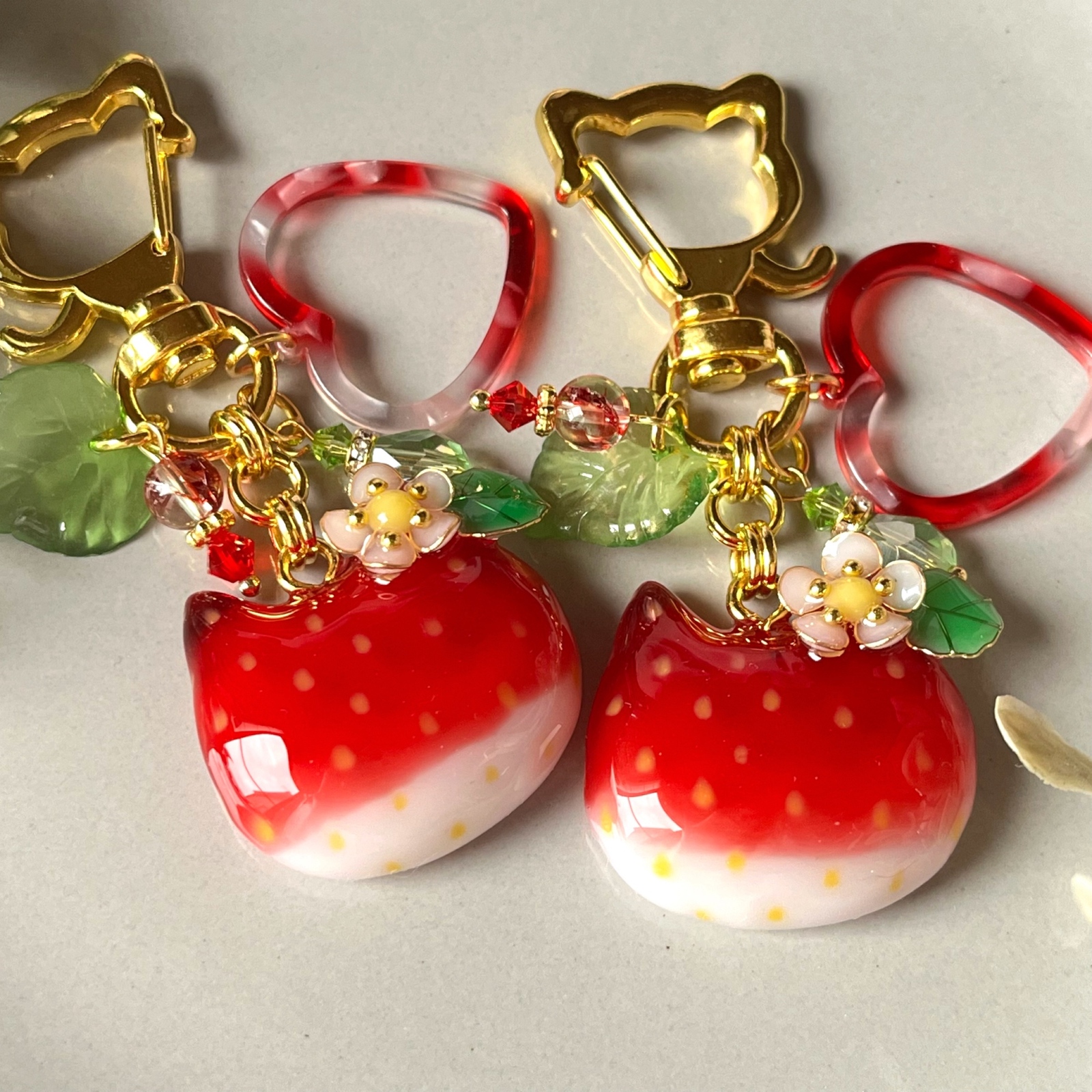 【2389】ぐでねこ　チャーム　レジン　キーホルダー　苺　猫柄　ハンドメイド 受注制作]ねこ型 苺のキーホルダー レジン 猫 いちご フェイク