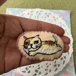 ハンドメイド　猫刺繍ブローチ　寝転びながら問いかける猫