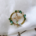 ROBIN THE SNOWサークルブローチ［葉っぱ　リーフ　弓矢　緑　グリーン　ビジュー　キュービックジルコニア　丸　円　リース　雪組　宝塚　ロビンザヒーロー　フッド］