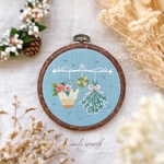 【カゴバックとかすみ草ブーケの刺繡フレーム水色】大切な方への贈り物やご自宅用に。オイルパステルで描いた手作りのカード付き。おうち時間を優しく彩る刺繍インテリア。
