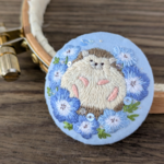 【minne'sセレクト掲載】ネモフィラとハリネズミの刺繍ブローチ｜くるみボタン・春の花アクセサリー・手刺繍《送料無料》