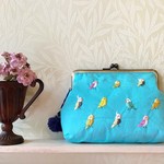 「カラフルインコ柄」の刺繍がま口ポーチ　スカイブルー