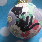 マカロンケースのストラップ　(お花の中から黒猫さん　ピンク)