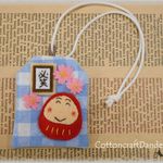 【完成品】思いを伝えるお守り袋♪桜とだるま「必笑」水色