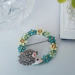 ハリネズミとブルーのお花たち。リングブローチ。つまみ細工