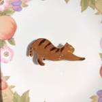 伸びをするトラ猫ちゃんの帯留め