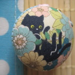 マカロンケースのストラップ　(お花の中から黒猫さん　水色)