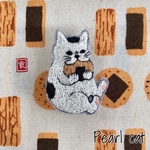 硬いお煎餅に挑む猫の刺繍ブローチ