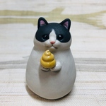 💩を持つハチワレねっこの置物