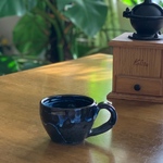 海の白波のような青白い眺めの美しい黒のコーヒーカップ