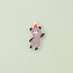 手を振るクマのブローチ