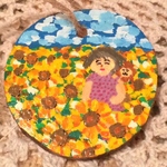 お守りみたいな木札の絵付け（ひまわりと女の人とおサル）
